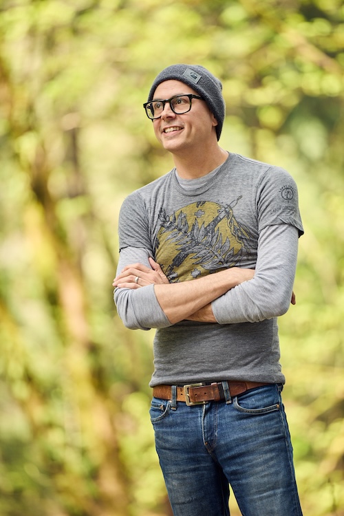 Photo of Daniel Wilson with beanie and glasses and arms crossed smiling